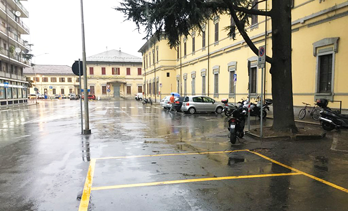 Ubriaco sdraiato in piazza stazione sotto la pioggia, i passanti spaventati chiamano la polizia locale 
